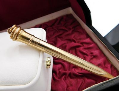a gold pen sitting inside of a box on a red cloth