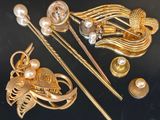 une broche en or ornée de perles et d'autres bijoux sur un fond noir