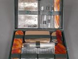 a green case with silverware in it on a gray surface