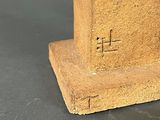a statue of a clock on a pedestal on a table