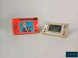 a small electronic game that is sitting next to a box