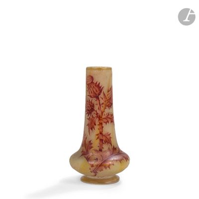 un petit vase avec un motif sur une surface blanche