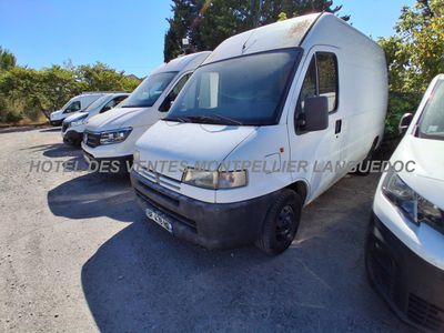 La camionnette blanche est garée à côté d'autres camionnettes sur le parking.