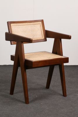 La chaise est en bois et possède une assise tressée.