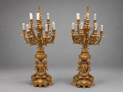une paire de candélabres en bronze doré avec des bougies
