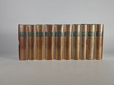 six livres anciens alignés sur une surface blanche