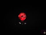 a close up of a red ball on a black surface