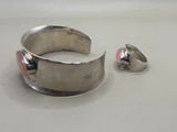 pair of silver rings with pink stones on them sitting on a white surface
