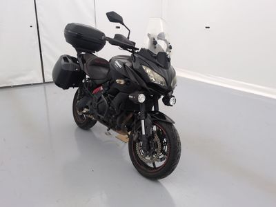 une moto noire garée dans une pièce aux murs blancs