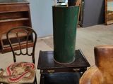 a green vase sitting on a table next to a chair