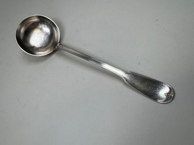 a silver spoon with a spoon handle on a table