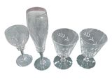 trois verres à pied en verre transparent et un verre à vin sur fond blanc