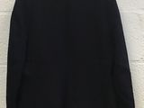 the back of a black jacket hanging on a white wall