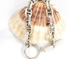 a shell with a chain around it on a white surface