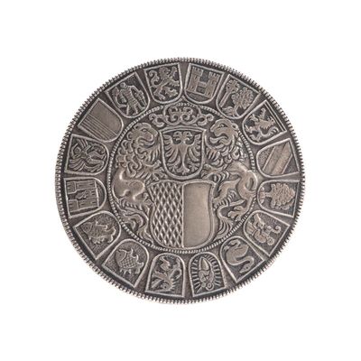 une image représentant une pièce d'argent sur laquelle figure un blason