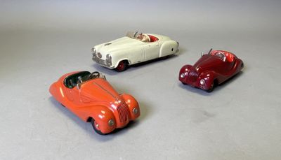 trois voitures jouets assises l'une à côté de l'autre sur une table