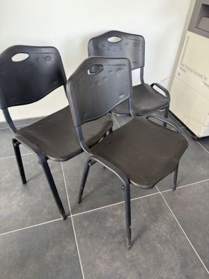 trois chaises assises l'une à côté de l'autre sur le sol