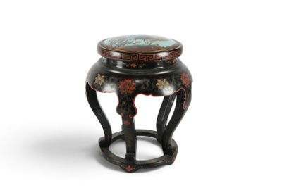 un petit tabouret noir dont l'assise est peinte sur fond blanc