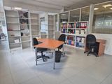 a room with a table, chairs, and bookshelves in it