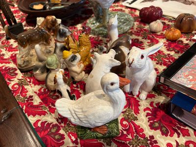 de nombreuses figurines posées sur une table recouverte d'une nappe rouge