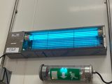 une lampe bleue accrochée au mur à côté d'un briquet