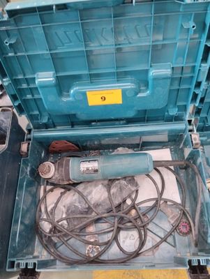 une boîte bleue contenant des fils et une perceuse