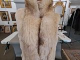 a mannequin in the middle of a room with a coat on it
