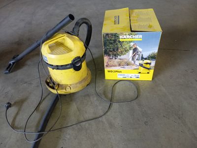 un aspirateur posé sur le sol à côté d'une boîte