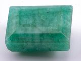 a green emerald stone on a white surface