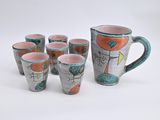 six cups and a pitcher on a white table