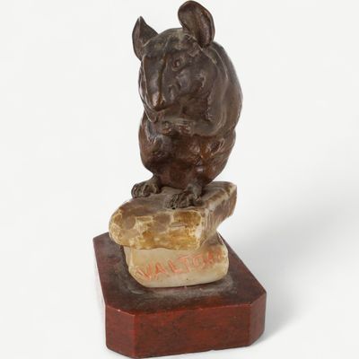 statue of a dog sitting on a rock on a marble base