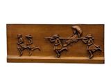 a close up of a wooden plaque with a man on a horse