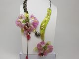 Ensemble collier et boucles d'oreilles à fleurs violettes et vertes, présenté sur un mannequin blanc