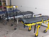 une civière jaune posée dans un garage à côté d'une voiture blanche