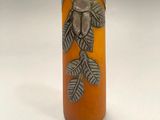 an orange vase with a bird on it sitting on top of a table
