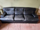 un canapé en cuir noir dans un coin du salon