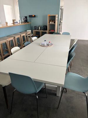 une table blanche et des chaises bleues dans une pièce