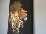 un tableau représentant un lion accroché au mur au-dessus d'un lit