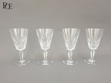 quatre verres à vin transparents posés sur une table blanche
