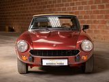 a red car that is parked in front of a brick wall
