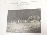 a black and white photo of a group of people riding horses