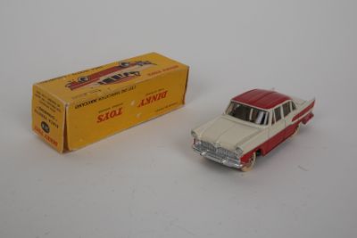 a red and white toy car next to a yellow box