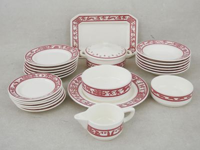 several red and white dishes and cups and saucers on a table