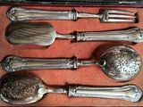 a set of silverware in a case on a table