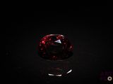 a close up of a red diamond on a black surface