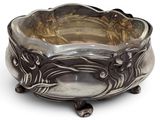 a silver bowl that is sitting on a white surface