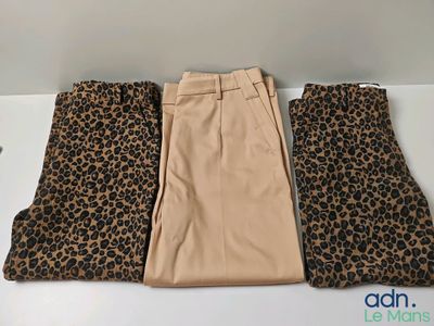 three pairs of pants with leopard print on them sitting on a table