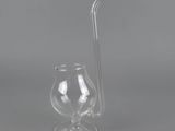 a close up of a glass with a straw next to it