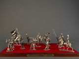 a group of silver figurines of soldiers on a red carpet