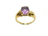 gros plan d'une bague en or avec une pierre violette